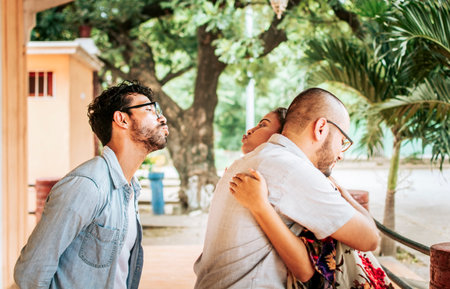 Unfaithful girlfriend hugging her boyfriend outdoors and secretly kissing another man, Unfaithful...
