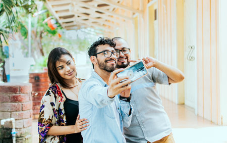 Three friends taking a selfie outside, Three smiling friends taking a selfie on the street. Front...
