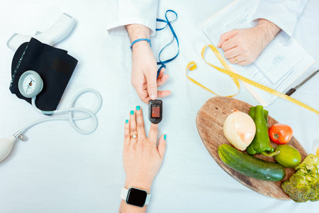 Nutritionist measuring oxygen pulse to patient, Close up of hands of nutritionist using pulse...