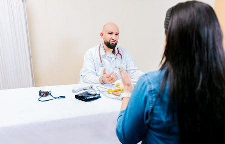 Back view of a female patient talking to the nutritionist. Smiling nutritionist explaining to a...