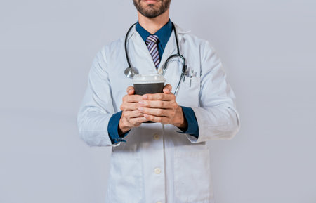 Doctor hands holding paper coffee. Doctor holding takeaway coffee on isolated background, Young...