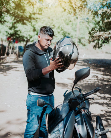 Man on motorcycle putting on helmet. Person on motorcycle putting on safety helmet. Biker motorcycle...