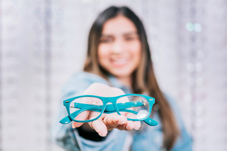 Girl hands showing some glasses in a store. Buyer showing glasses in a store. Happy girl holding...