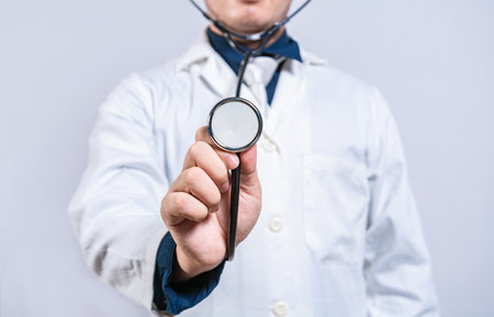 Close up of doctor showing stethoscope medical isolated. Unrecognizable doctor holding a stethoscopeの写真素材