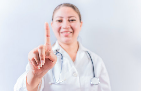 Female doctor counting number ONE isolated. Young female doctor counting number 1 on isolated backgroundの写真素材