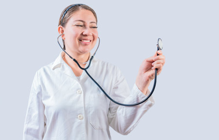 Smiling female doctor hand holding stethoscope isolated. Young female doctor holding stethoscope on white backgroundの写真素材