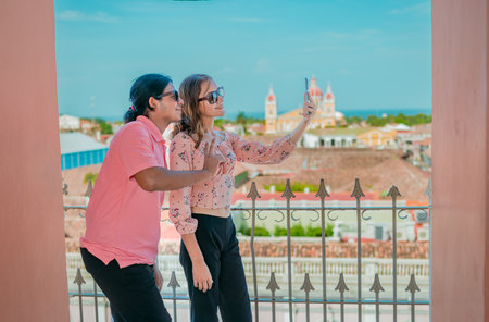 Tourist couple taking a selfie at the viewpoint of the La Merced church. Happy tourists taking self...