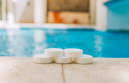 Chlorine tablets for disinfection and purification of swimming pools. Chlorine tablets with background of a crystal clear poolの写真素材