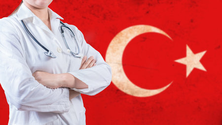 Healthcare concept with Turkish flag in background. Portrait of doctor with crossed arms with Turkish flag in the backgroundの写真素材