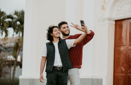 Cheeful friends taking funny selfie on the street. Portrait of funny friends taking a selfie on the streetの写真素材