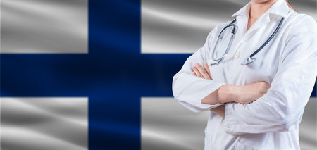 Doctor with crossed arms on Finland flag. Finland Health and Care concept. Female doctor on Finland flagの写真素材