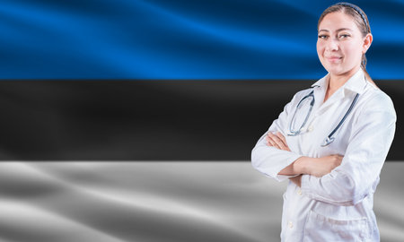 Female Doctor On Estonian Flag. Doctor With Crossed Arms On Estonian Flag. Estonia Health And Care Conceptの写真素材