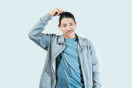 Confused guy scratching head isolated. Worried man scratching head with confused face isolatedの写真素材