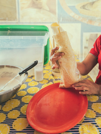 Vendor serving delicious quesillo in a bag. Hands of a person serving traditional quesilloの写真素材