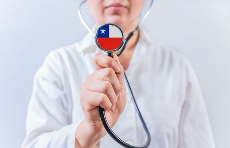Female doctor holding stethoscope with Chile flag. National health system of Chileの写真素材