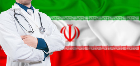 Iran healthcare concept. Male doctor on Iran flag. Doctor with crossed arms on Iran flagの写真素材