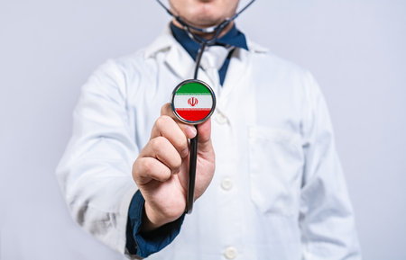 Doctor hands holding stethoscope with Iran flag. Iran health and care conceptの写真素材