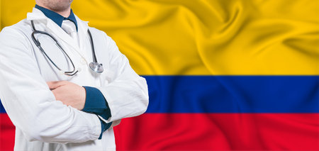 Colombia healthcare concept. Male doctor on Colombia flag. Doctor with crossed arms on Colombia flagの写真素材