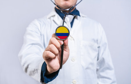 Doctor hands holding stethoscope with Colombia flag. Colombia health and care conceptの写真素材