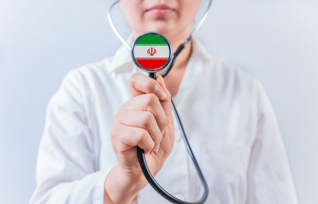 Female doctor holding stethoscope with Iran flag. National health system of Iranの写真素材