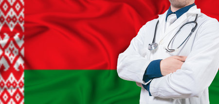 Belarus healthcare concept. Male doctor on Belarus flag. Doctor with crossed arms on Belarus flagの写真素材
