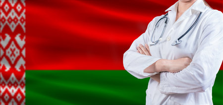 Doctor with crossed arms on Belarus flag. Belarus health and care concept. Female doctor on Belarus flagの写真素材