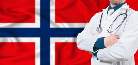 Norway healthcare concept. Male doctor on Norway flag. Doctor with crossed arms on Norway flagの写真素材