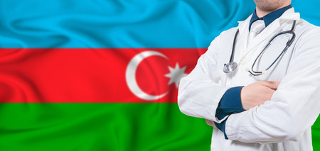 Azerbaijan healthcare concept. Male doctor on Azerbaijan flag. Doctor with crossed arms on Azerbaijan flagの写真素材