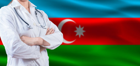 Doctor with crossed arms on Azerbaijan flag. Azerbaijan health and care concept. Female doctor on Azerbaijan flagの写真素材