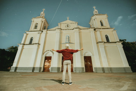 Tourist with open arms at the Esteli Cathedral, Nicaragua. Man with open arms at the Esteli Cathedral, Our Lady of the Rosaryの写真素材