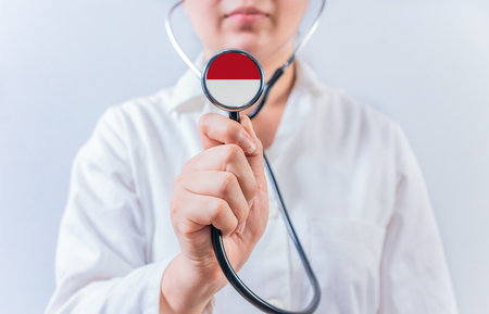 Female doctor holding stethoscope with Monaco flag. National health system of Monacoの写真素材