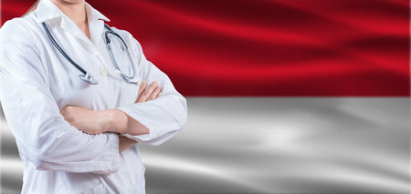 Doctor with crossed arms on a flag. Health and care concept. Female doctor on a flagの写真素材