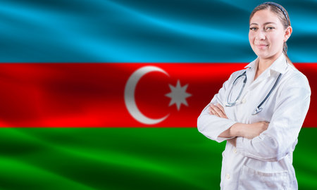Female doctor on Azerbaijan flag. Doctor with crossed arms on Azerbaijan flag. Azerbaijan health and care conceptの写真素材
