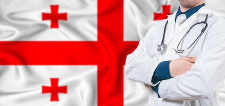 Georgia healthcare concept. Male doctor on Georgia flag. Doctor with crossed arms on Georgia flagの写真素材