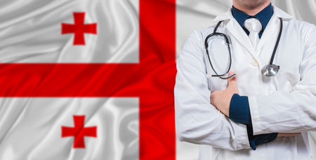 Male doctor with stethoscope on Georgia flag. Doctor holding stethoscope on Georgia flagの写真素材