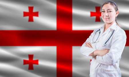 Female doctor on Georgia flag. Doctor with crossed arms on Georgia flag. Georgia health and care conceptの写真素材