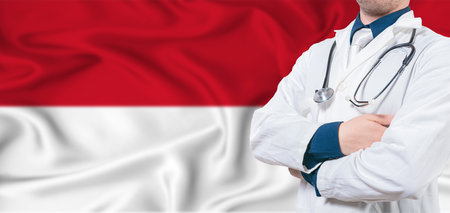 Healthcare concept. Male doctor on flag. Doctor with crossed arms on flagの写真素材