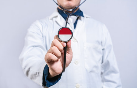 Doctor hands holding stethoscope with Monaco flag. Health and care conceptの写真素材