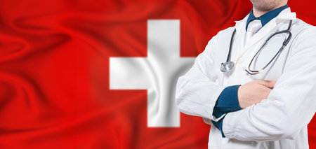 Switzerland healthcare concept. Male doctor on Switzerland flag. Doctor with crossed arms on Switzerland flagの写真素材