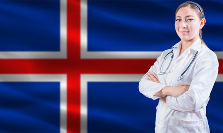 Female doctor on Iceland flag. Doctor with crossed arms on Iceland flag. Iceland health and care conceptの写真素材