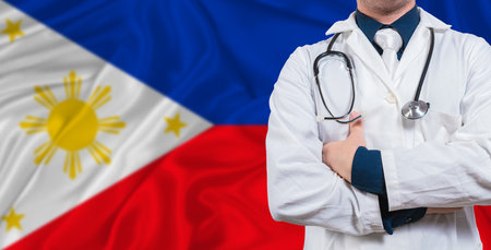 Male doctor with stethoscope on Philippines flag. Doctor holding stethoscope on Philippines flagの写真素材