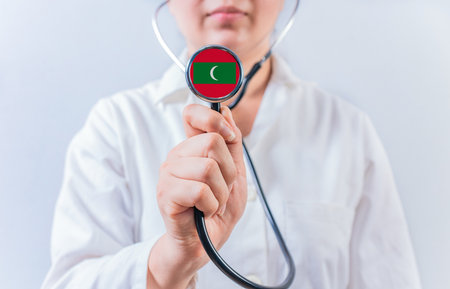 Female doctor holding stethoscope with Maldives flag. National health system of Maldivesの写真素材