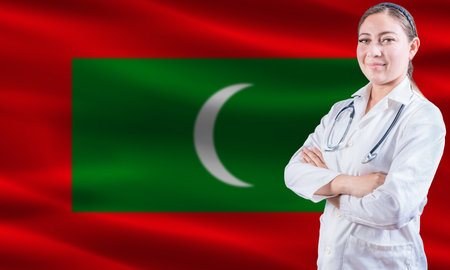 Female doctor on Maldives flag. Doctor with crossed arms on Maldives flag. Maldives health and care conceptの写真素材