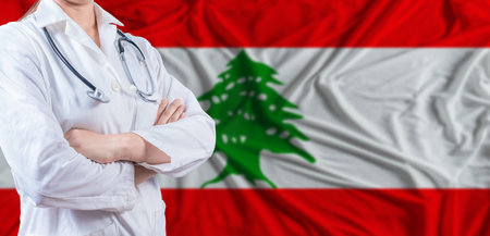 Doctor with crossed arms on Lebanon flag. Lebanese health and care concept. Female doctor on Lebanon flagの写真素材