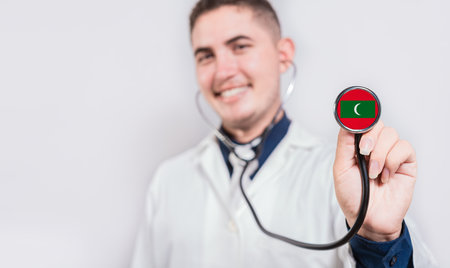 Doctor showing stethoscope with Maldives flag. Maldives national healthcare conceptの写真素材