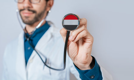 Doctor holding stethoscope with Yemen flag. Yemen health and care concept, Yemen flag on stethoscopeの写真素材