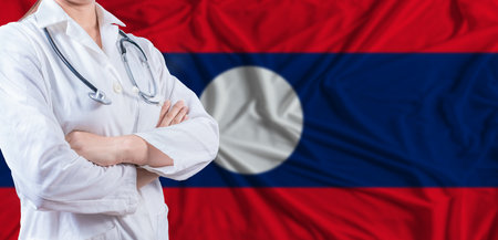 Doctor with crossed arms on Laos flag. Laotian health and care concept. Female doctor on Laos flagの写真素材
