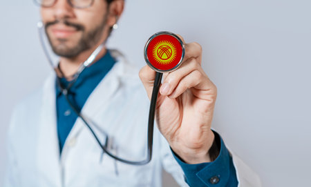Doctor holding stethoscope with Kyrgyzstan flag. Kyrgyzstan health and care concept, Kyrgyzstan flag on stethoscopeの写真素材
