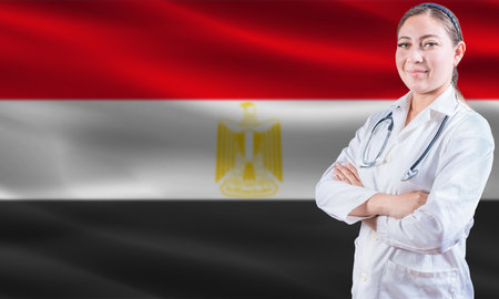 Female doctor on Egypt flag. Doctor with crossed arms on Egypt flag. Egypt health and care conceptの写真素材