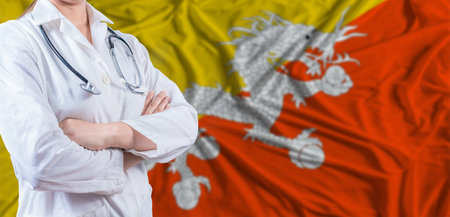 Doctor with crossed arms on Bhutan flag. Bhutan health and care concept. Female doctor on Bhutan flagの写真素材